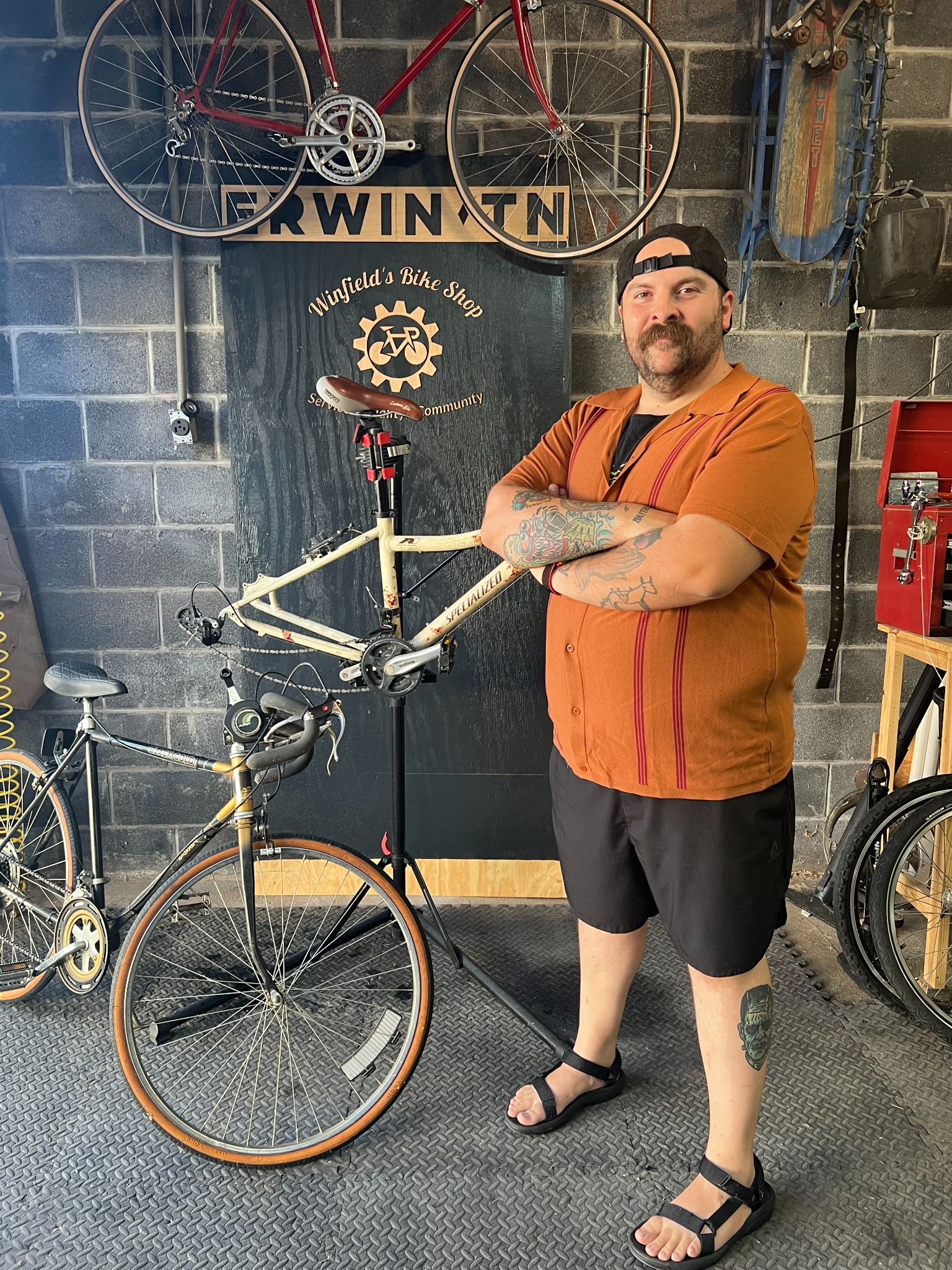 Winfield’s owner standing with a bicycle in the workshop